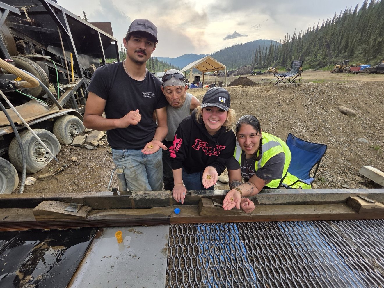 Family and crew gathered beside sluice equipment.