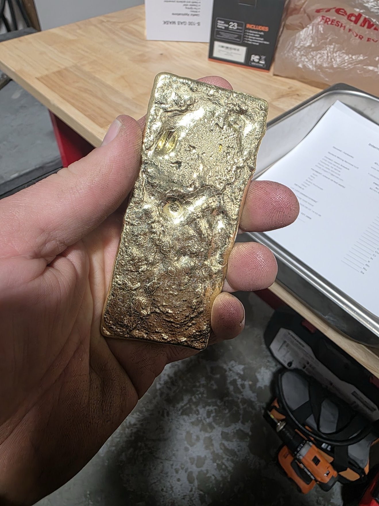 Close-up of a gold bar held in hand.