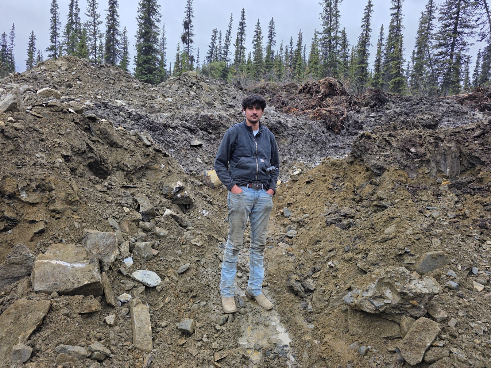 Crew member standing in an excavated cut on the claim.