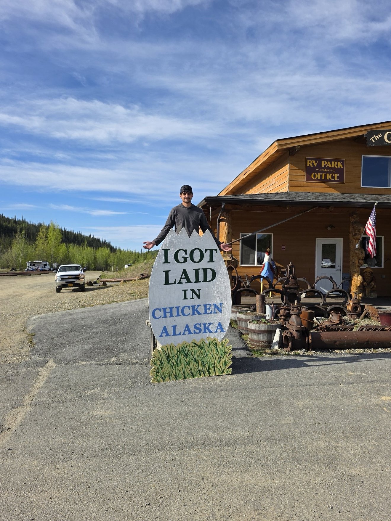 Roadside novelty sign outside a rustic Alaska stop.