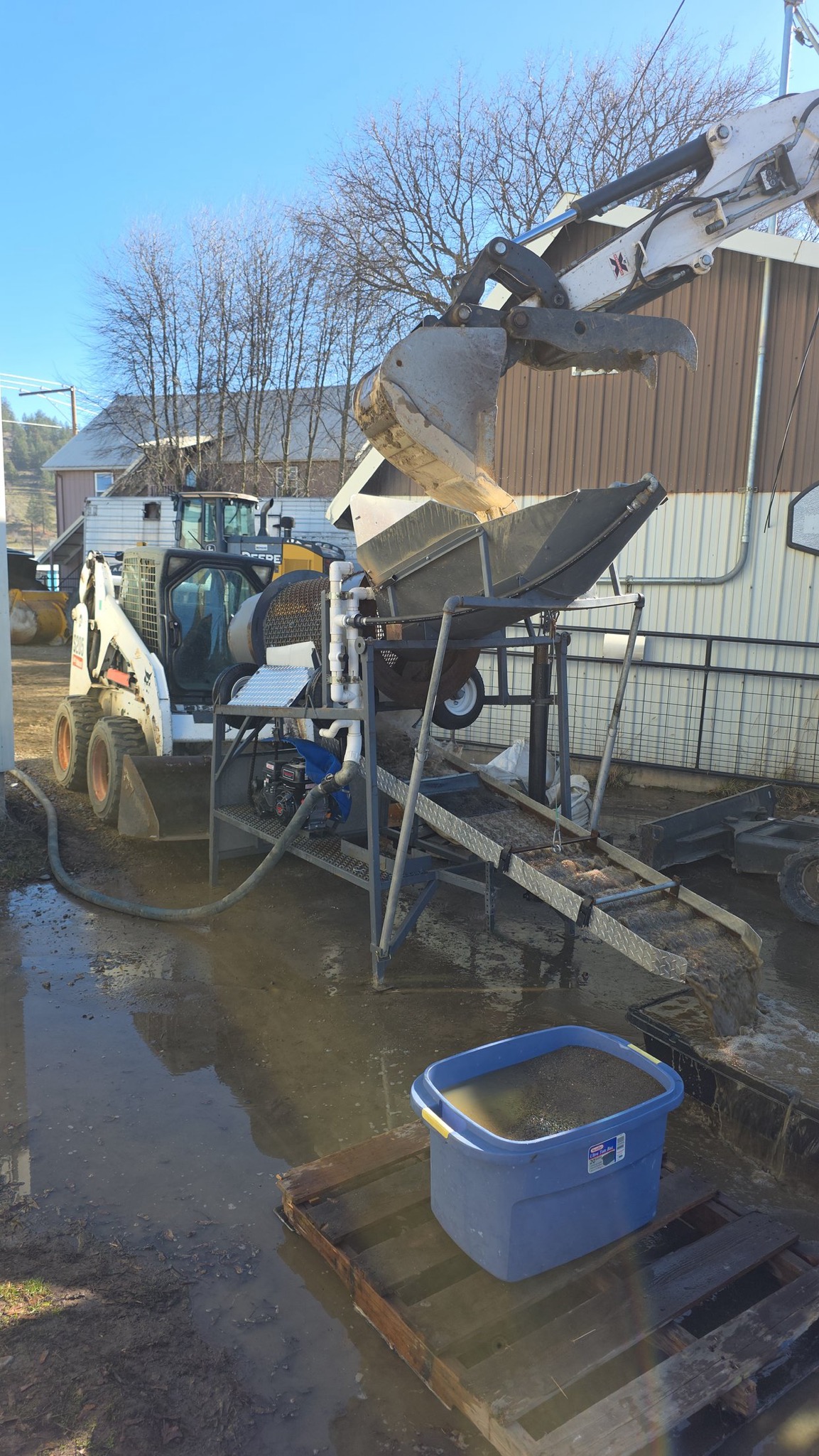 Skid steer feeding material into a hopper.