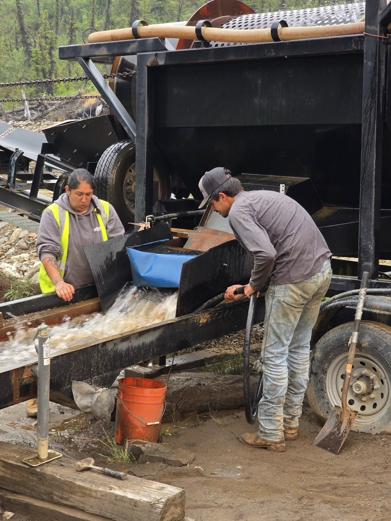 Crew working around sluice equipment during cleanup.